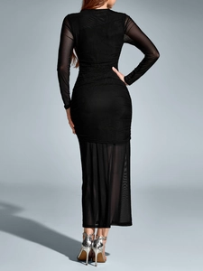 Detail of the back view of this black mesh long sleeve dress with ruched bodycon design