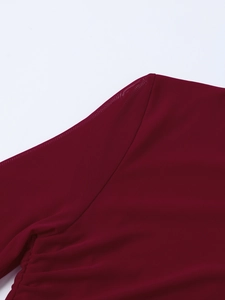 Vue détaillée du tissu en maille transparente bordeaux et des coutures sur l'épaule