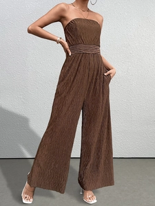 Détail du tissu marron texturé avec volants et poches latérales sur la combinaison