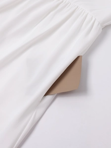 Detail view of the side seam invisible pocket on a white lace patchwork summer dress