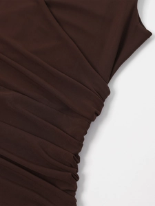 Detail view of brown mesh fabric showing elegant ruching and pleated textures on the dress