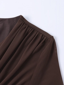 Vue détaillée du tissu en maille marron avec plis délicats et col drapé sophistiqué