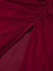 Détail de la fente latérale et de la texture en maille plissée de la robe bordeaux