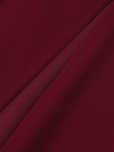 Gros plan détaillé sur la texture du tissu en maille rouge foncé et les coutures de la robe