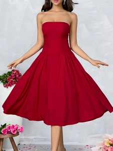 Detailed view of the pleated waist and flowing red tube top midi dress silhouette