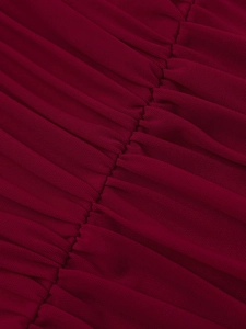 Détail macro de la robe en mesh bordeaux montrant la texture froncée et la couture fine