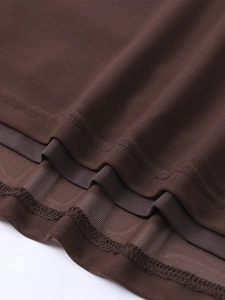 Détail de l'ourlet à double couche sur une robe moulante en maille marron foncé