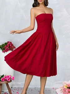 Close-up of red strapless dress featuring elegant pleated waist and flowing A-line skirt