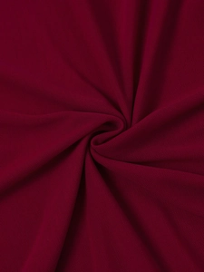 Détail du tissu en maille bordeaux montrant une texture fine et des plis élégants
