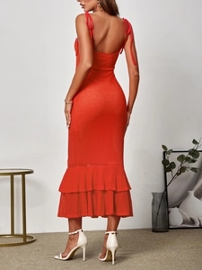 Detail of red knitted maxi dress showing backless design and layered ruffle hemline