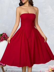 Detailed view of the side waist pleats on a red strapless midi dress with slim fit design