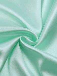 Detail of mint green matte satin fabric with smooth texture and elegant drapes