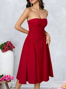 Detail of red strapless A-line dress featuring elegant waist pleats and ruffled hemline