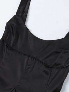 Détail du haut élégant en satin noir à col carré montrant le tissu lisse et les coutures