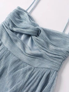 Macro detail of sky blue metallic pleated fabric with twist-knot and cutout design