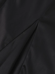 Détail du tissu en satin noir élégant montrant la texture plissée et le fini brillant