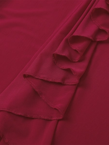 Détail du tissu en maille bordeaux avec bords à volants et texture plissée fine