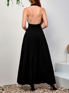 Détail élégant du dos nu d'une robe longue en maille noire avec jupe trapèze plissée
