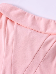 Detail shot of light pink bodycon dress showing textured fabric and tailored stitching