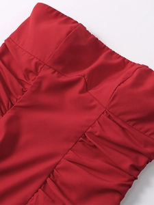 Close-up of side ruching and gathered fabric detail on a red strapless dress