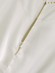 Detail of invisible zipper and lace embroidery on a matte satin summer long dress