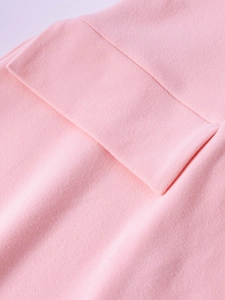 Close-up of pink knit dress sleeve showing the double-layered ribbed cuff and fabric texture