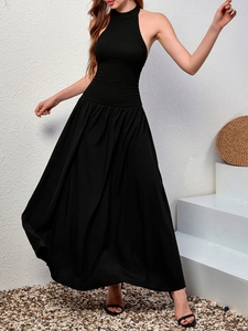 Détail de la robe longue dos nu noire avec un bustier plissé cintré et une jupe fluide
