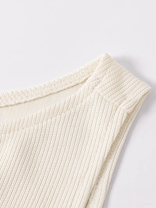 Detailed close-up of ribbed knit texture on a cream sleeveless bodycon dress