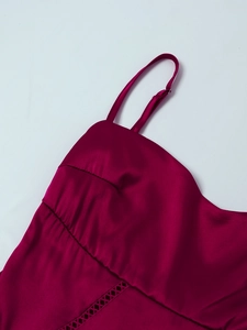 Detail of rose red satin dress featuring adjustable spaghetti straps and pleated bust