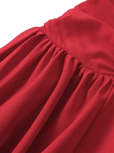 Macro view of bright red pleated fabric details on a strapless slim-fit midi dress