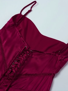 Detail of burgundy satin dress showing the adjustable corset lace-up back and metallic eyelets