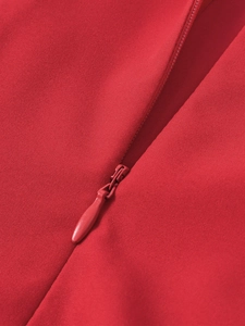 Detailed close-up of a high-quality red invisible zipper on a woven A-line dress
