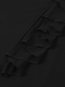 Détail de volants en maille noire avec coutures délicates sur une robe ajustée chic