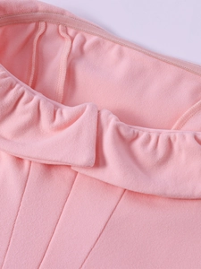 Close-up of pink strapless dress with ruffled edge and soft velvet-touch fabric