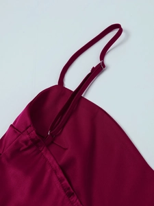 Close-up of adjustable strap with silver buckle on burgundy satin dress fabric