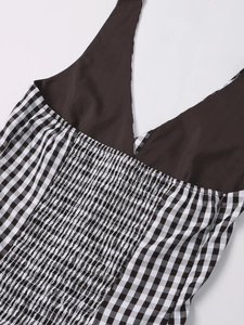 Detail of smocked elastic back and invisible side zipper on a gingham halter dress
