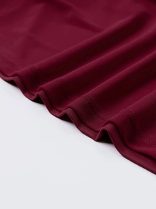 Close-up of burgundy mesh dress showing professional double-needle stitching and fabric texture