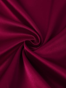 Macro shot of deep red matte satin fabric with silky texture and soft metallic sheen