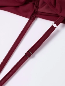 Close-up of adjustable straps and metallic hardware on a burgundy mesh bodycon dress
