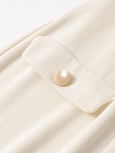 Macro shot of vertical rib knit fabric detail with a decorative gold button pocket