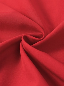 Detailed macro shot of deep red fabric texture with professional pleated folding effect