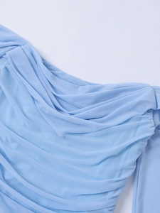 Detail of light blue mesh fabric showing textured pleats and soft sheer material draping