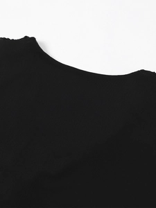 Détail de l'encolure en tulle noir avec bordure ondulée et plis délicats