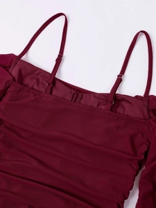 Detail of burgundy mesh dress showing adjustable thin straps with silver metal buckles