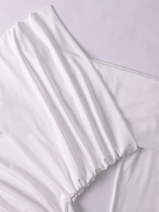 Detail of white milk silk dress featuring elegant side ruching and pleated fabric texture