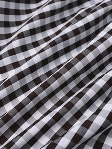 Close-up of black and white gingham fabric texture on a halter neck summer dress