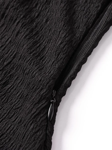 Détails du tissu noir texturé montrant des coutures fines et une fermeture éclair invisible