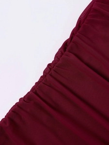 Detail of wine red mesh dress showing elegant ruching and premium fabric texture