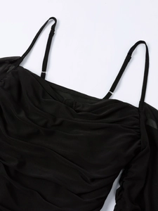 Close-up of black sheer mesh dress featuring thin straps and detailed ruching texture