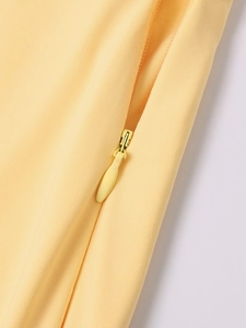Détail macro de la fermeture éclair invisible sur la robe longue jaune clair